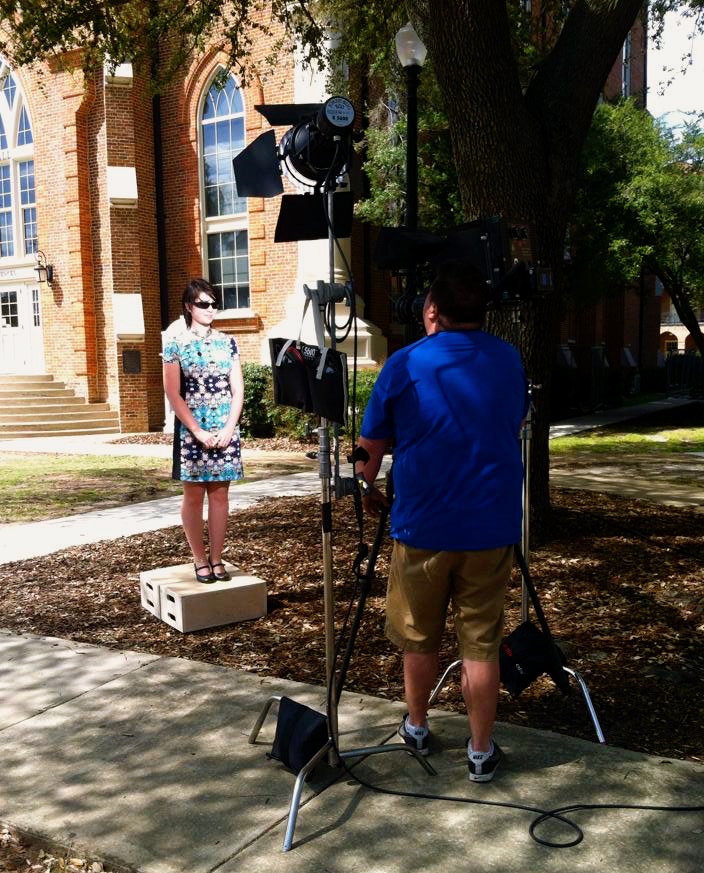 camera filming a student in front of Clark Hall