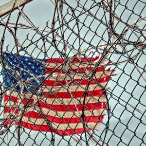 an American flag behind a chain-link fence